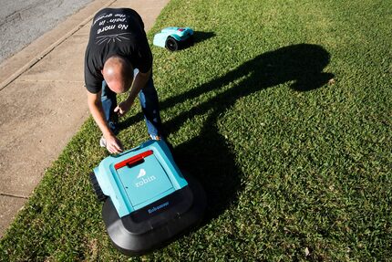 Robin co-founder and CEO Justin Crandall works with a few of the company's Roomba-like...