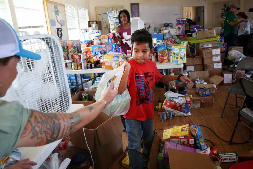 Volunteer Aiden Levario, 7, sorts through donated goods at the Trinity by the Sea Episcopal...