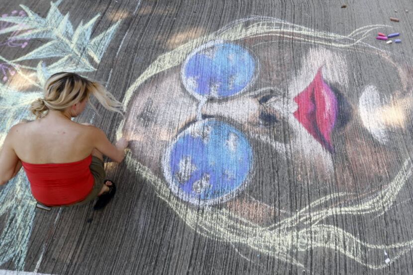 Dallas based artist Jenny Heissenhuber works on her chalk art at the Chalk-It Up! event in...
