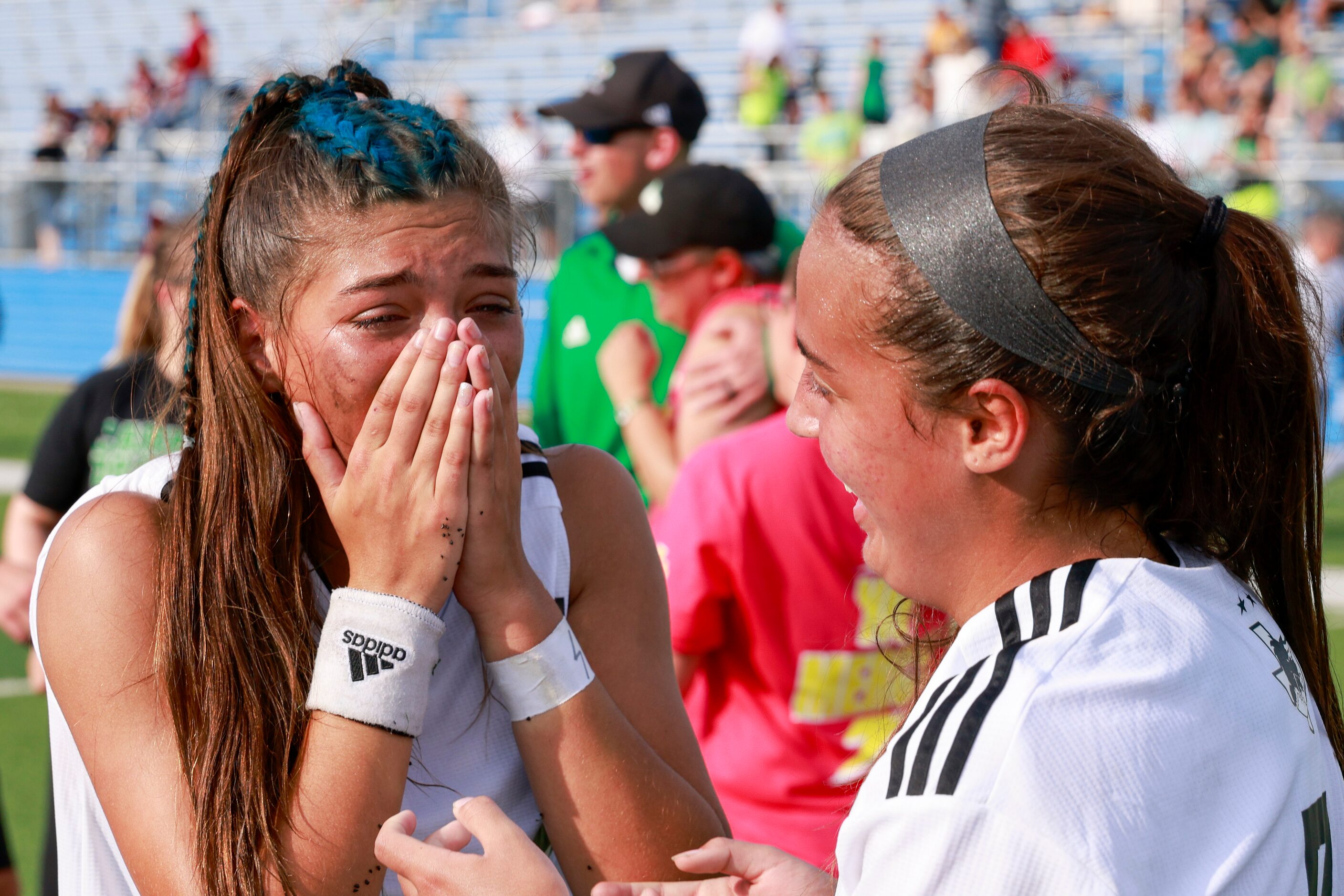 Southlake Carroll midfielder Bella Clahane comforts forward Madison Khan (left) who is...