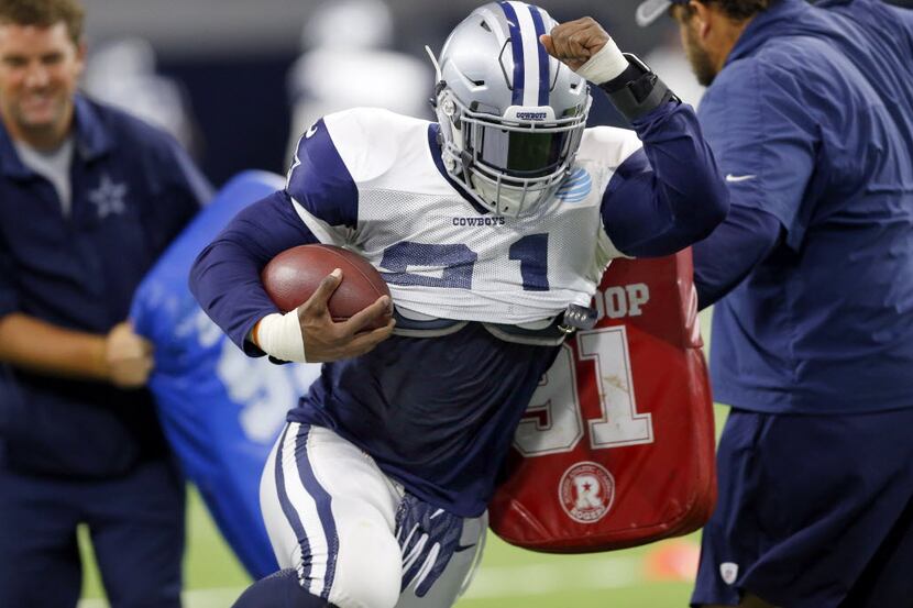 Dallas Cowboys running back Ezekiel Elliott (21) runs through a tackling drill during...