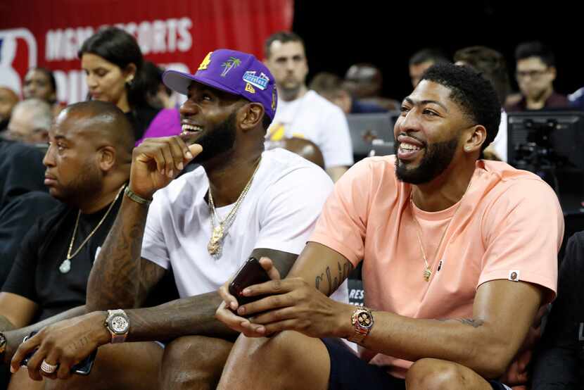 Los Angeles Laker players LeBron James, center, and Anthony Davis, right, take in an NBA...