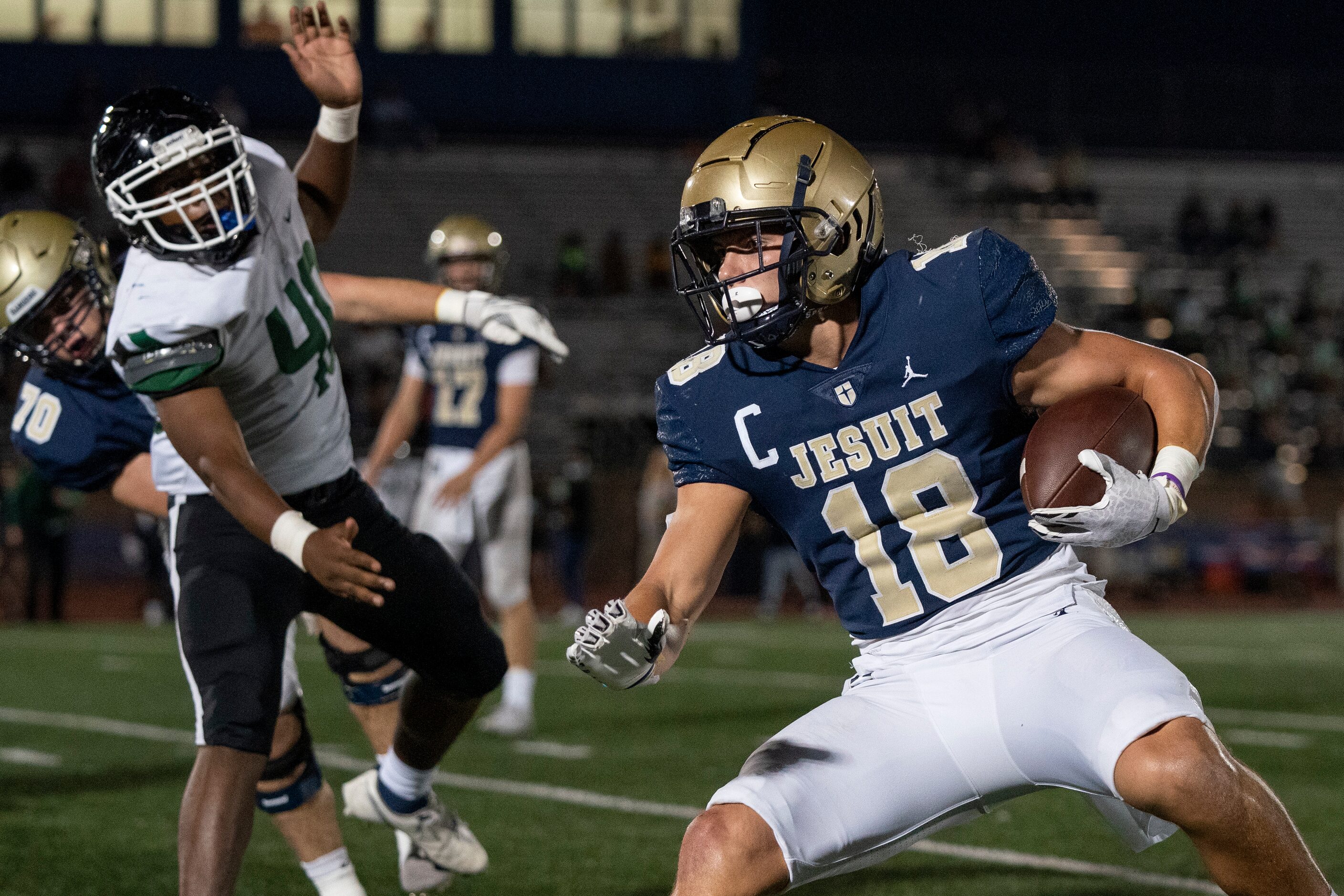 Jesuit senior running back Robert Fitzgerald (18) turns upfield past Richardson Berkner...