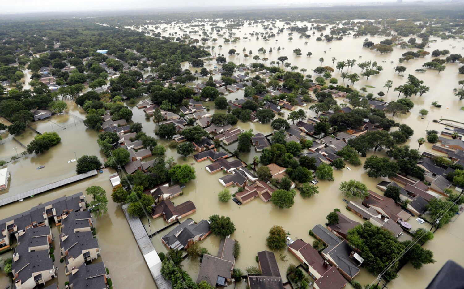 In this Aug. 29 photo, water from Addicks Reservoir flows into neighborhoods as floodwaters...