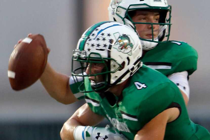 Southlake Carroll quarterback Will Bowers (14) fakes a handoff to running back T.J. McDaniel...