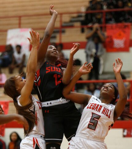 South Grand Prairie player Kayla Wells (12) lays up a shot against Cedar Hill guards Kayla...