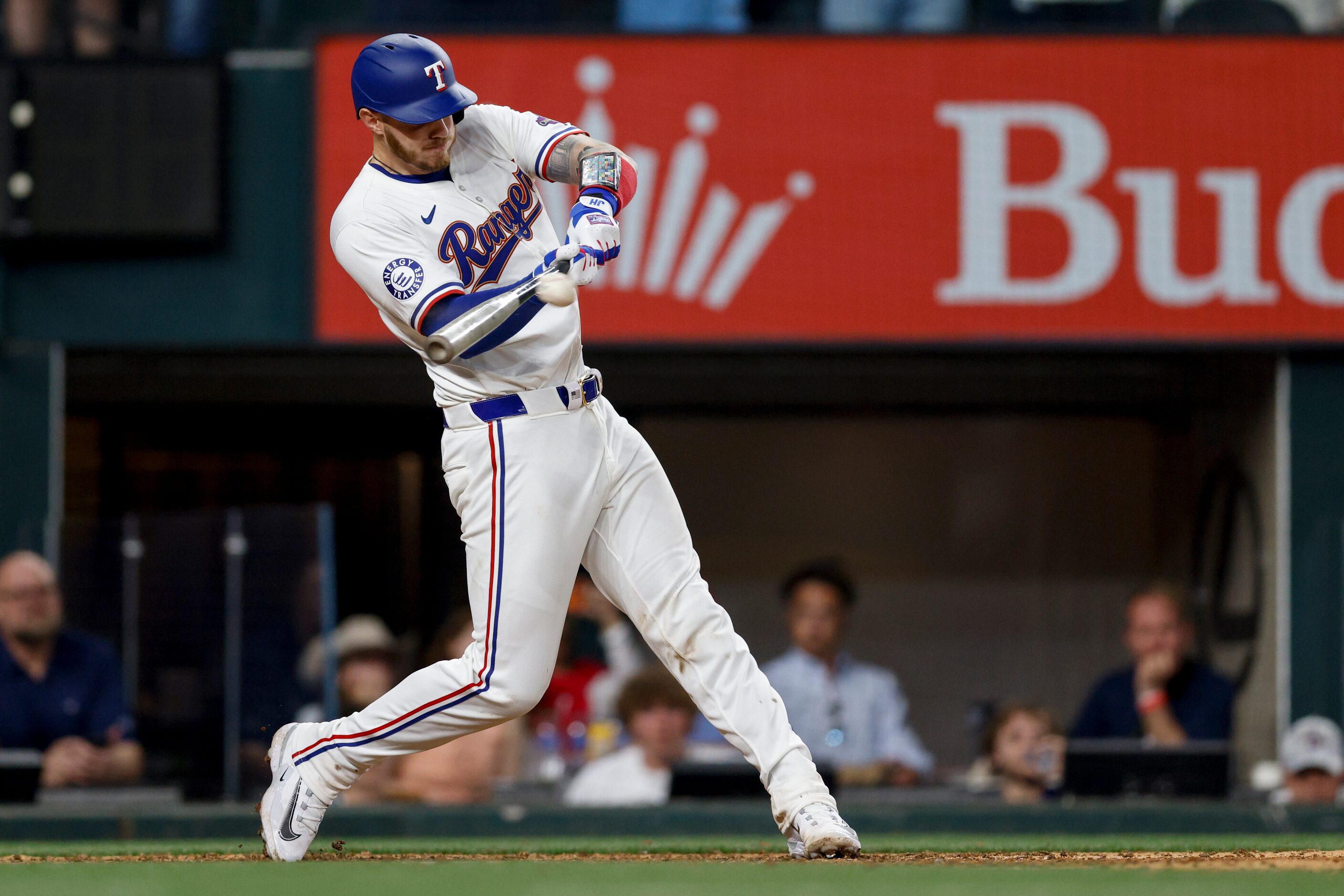 Texas Rangers catcher Jonah Heim (28) hits a single to center to score third baseman Josh...