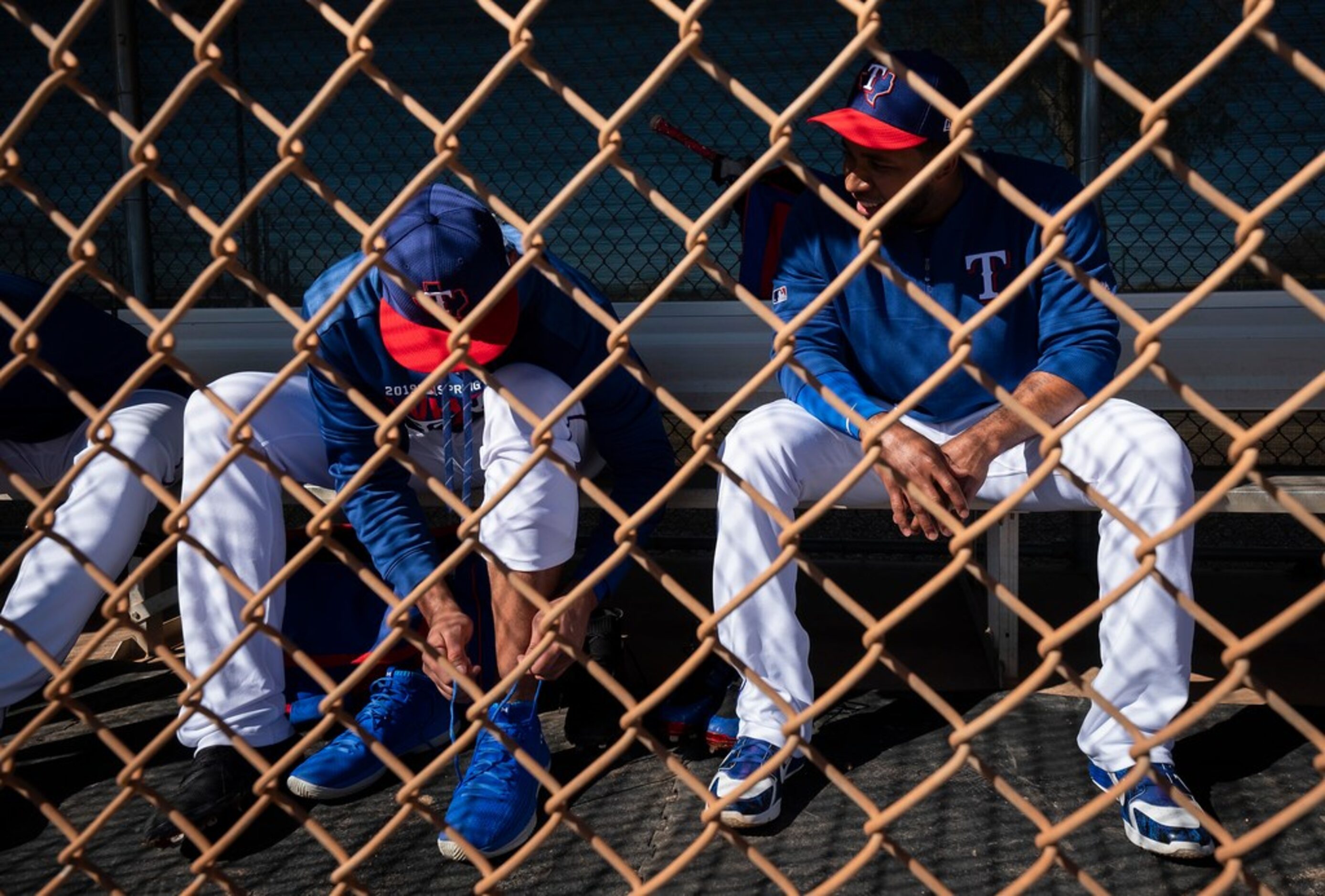 Texas Rangers shortstop Elvis Andrus (right) talks with infielder Ronald Guzman in a dugout...