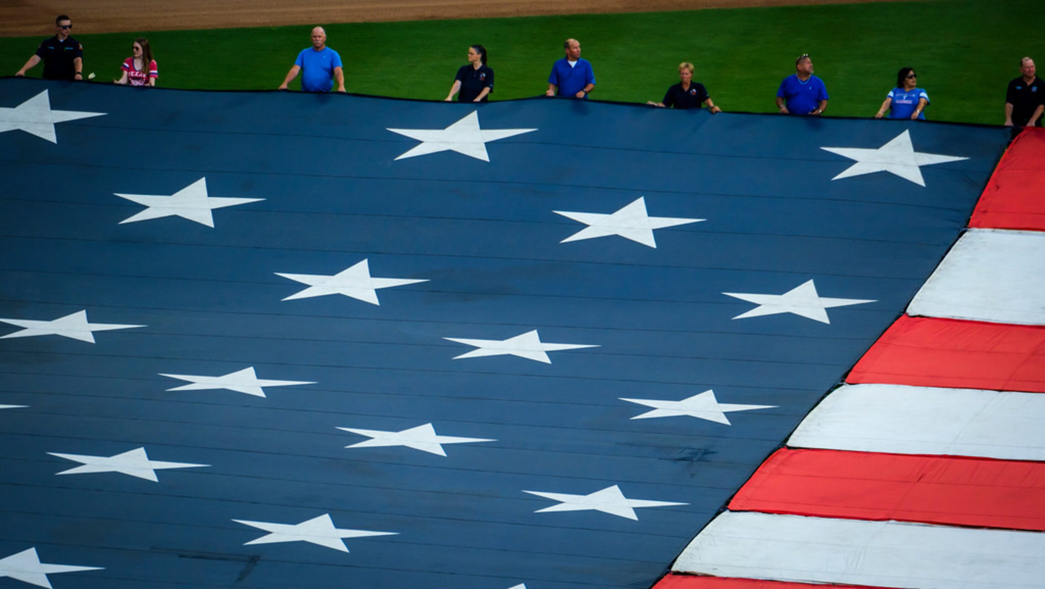 First responders from the Arlington police and fire departments unfurl large US flag at...