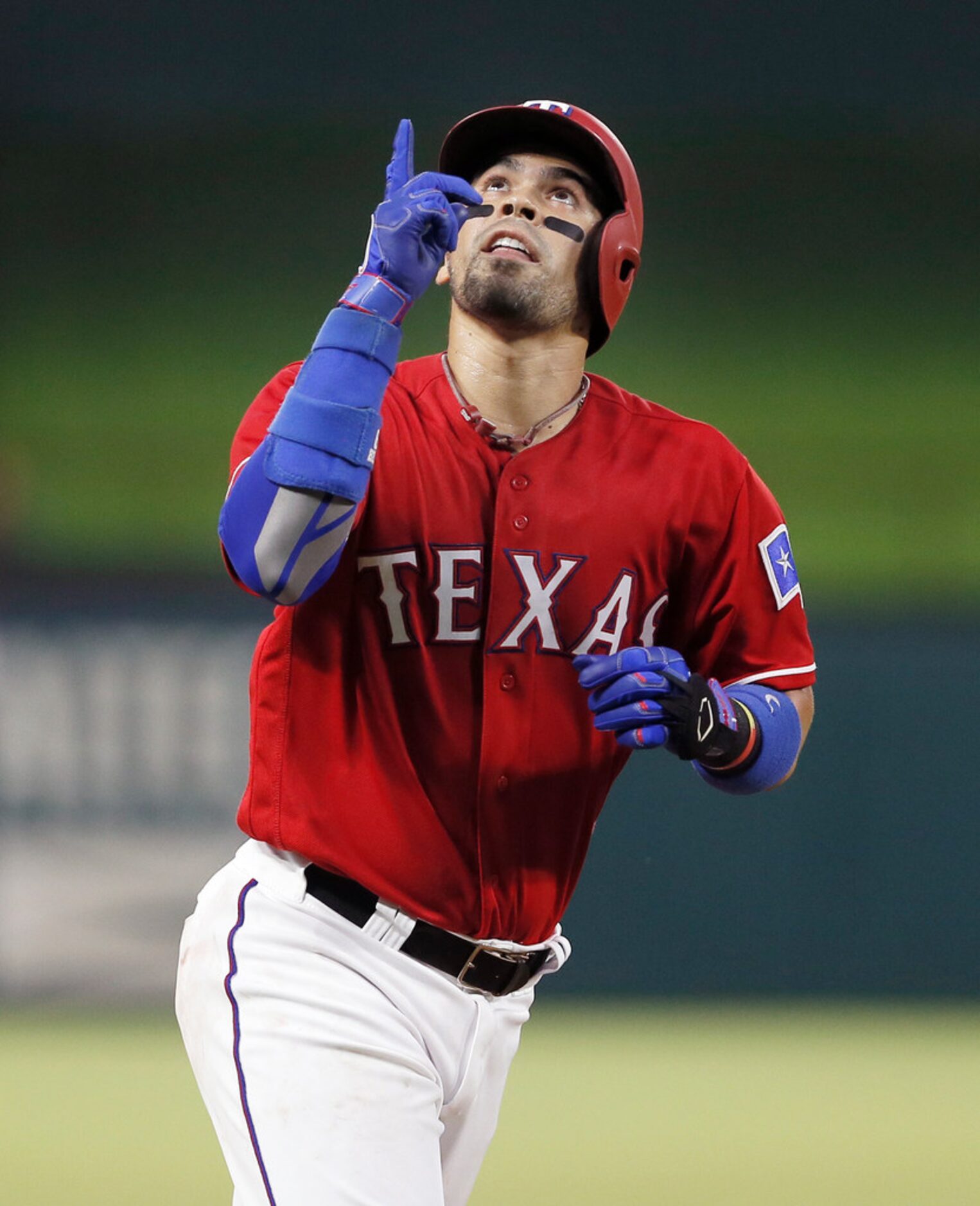 Texas Rangers' Robinson Chirinos points skyward after hitting a three-run home run during...