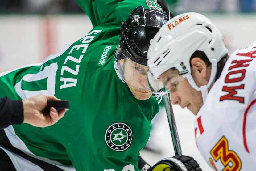 Dallas Stars center Jason Spezza (90) eyes the puck as he faces off against Calgary Flames...