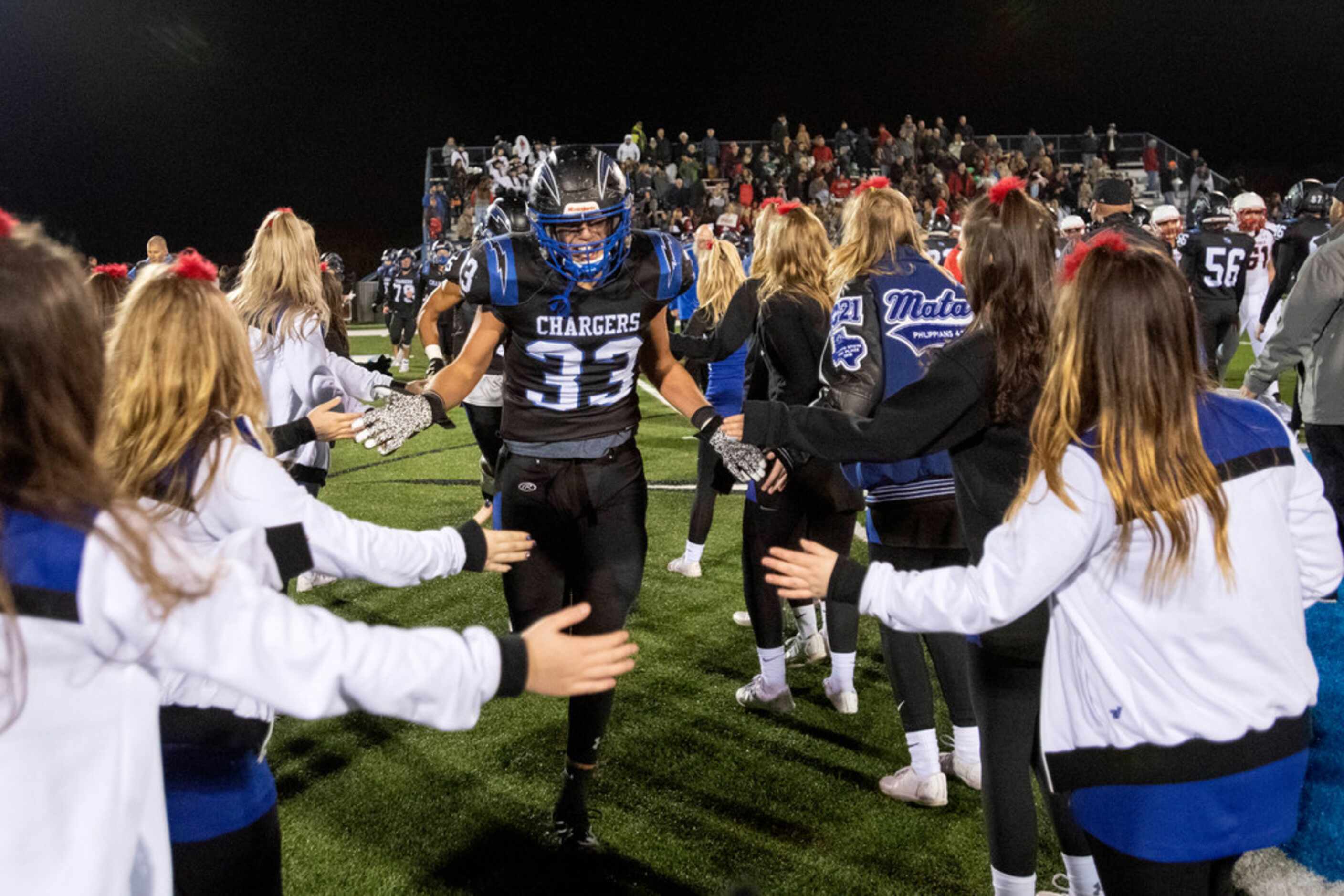 Dallas Christian junior Trevor Stegman (33) is congratulated by cheerleaders after his team...