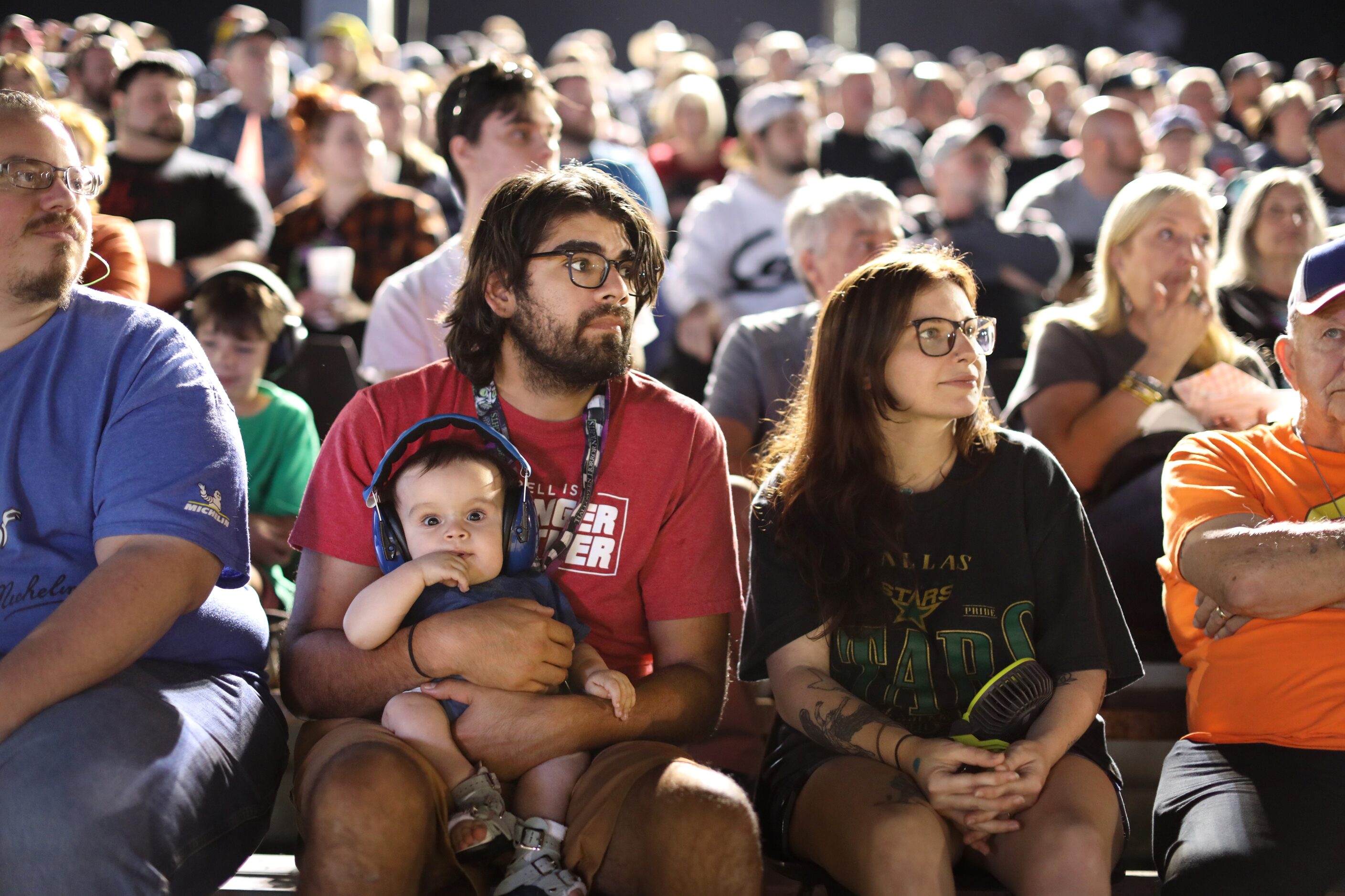 Edwin Rodriguez holds 10-month-old Bo Rodriguez, as he and Katie Rodriguez watch a race at...