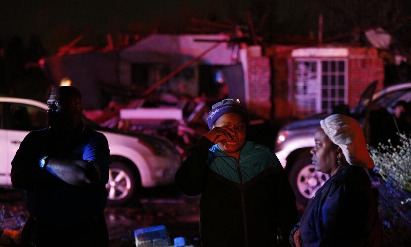 Margaret Young wiped her eyes while talking to neighbors after a storm lifted the roof from...