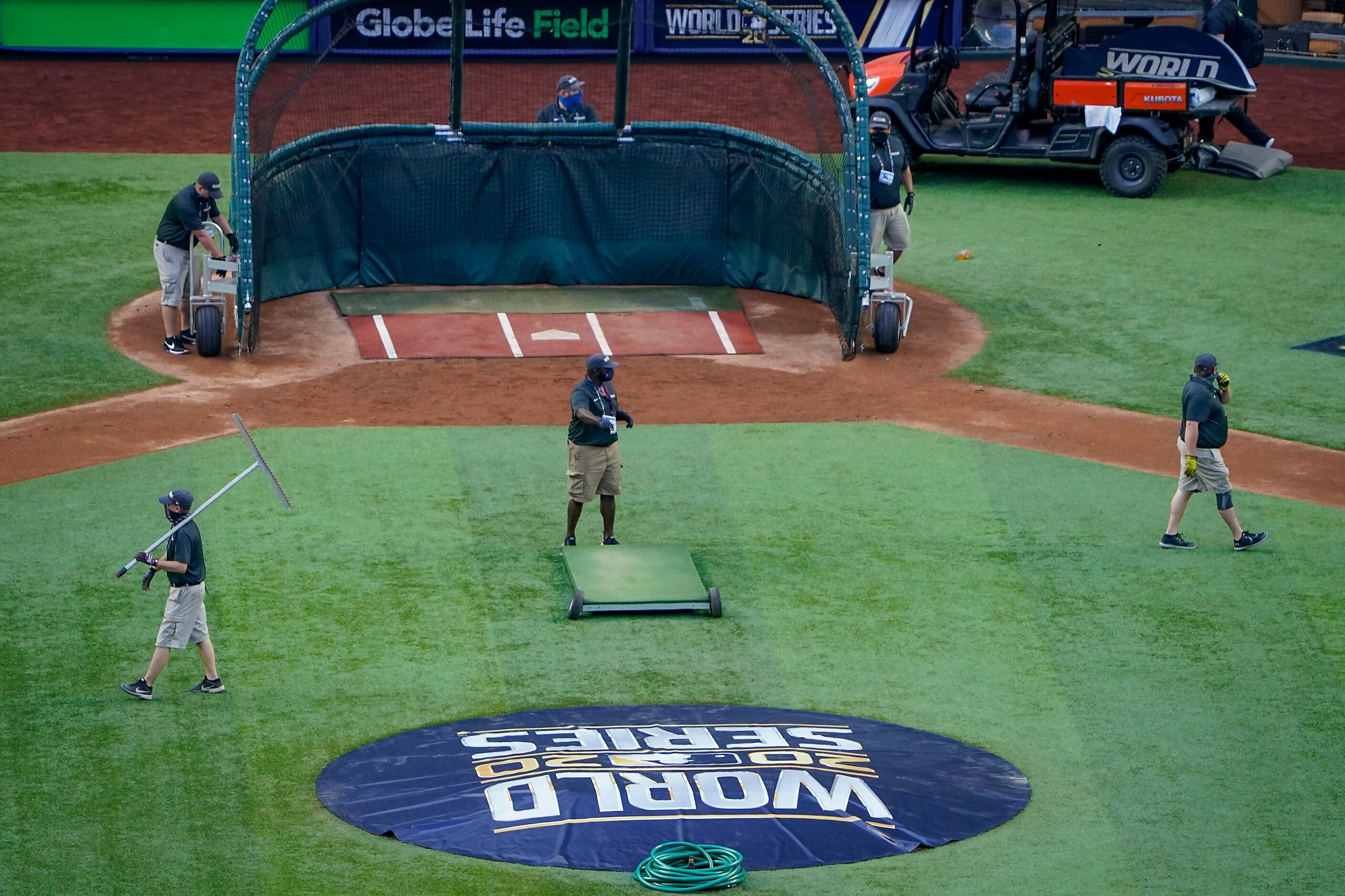 Groundskeepers prepare the field before Game 1 of the World Series between the Los Angeles...