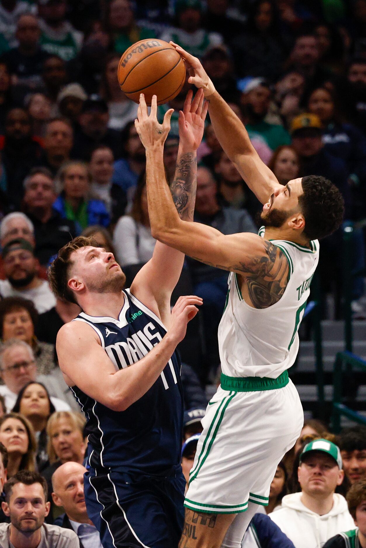 Boston Celtics forward Jayson Tatum (0) fouls Dallas Mavericks guard Luka Doncic (77) during...