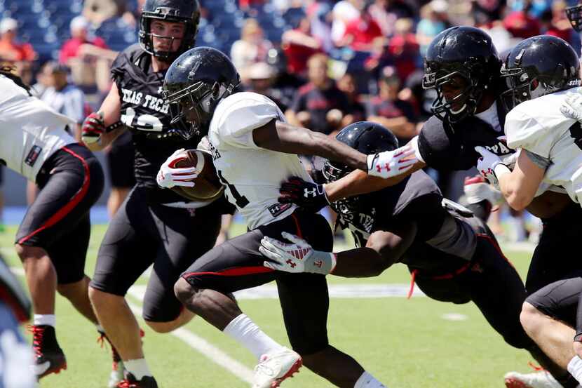 In this file photo, Texas Tech wide receiver Jakeem Grant pushes his way past defenders...