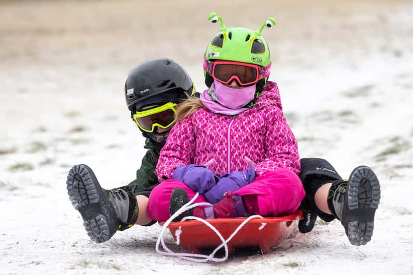 Madeline Daniel, 6, and her brother Riley, 8, played in the snow at Flag Pole Hill Park in...