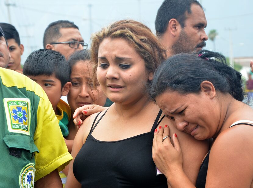 Relatives wanting information about their loved ones gather outside a beer distribution...