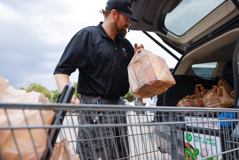 Michael Paddon, 41, of Dallas, unloads his groceries at a Kroger in East Dallas on Wednesday. 
