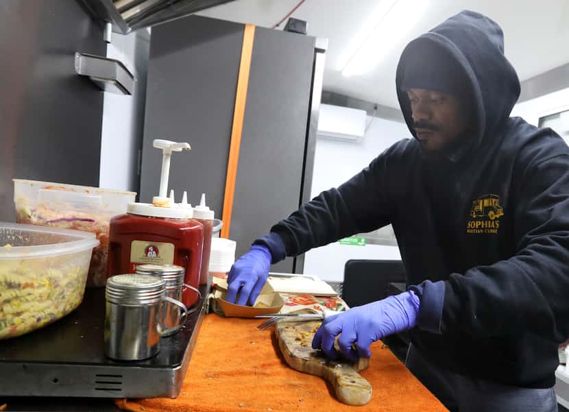 Kavin Adisson prepares some food in the Sophia's Haitian Cuisine food truck during the...