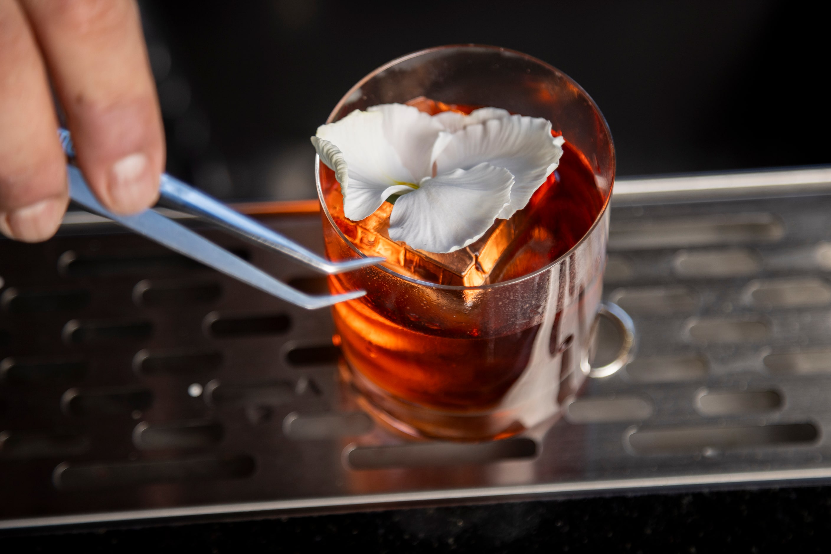 Beverage director Ravinder Singh places a flower on the Truffle Negroni cocktail at Wicked...