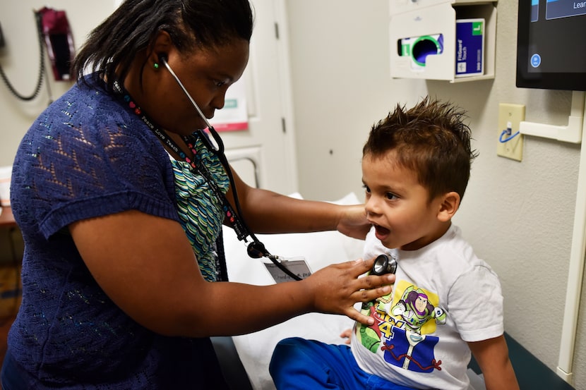 Nurse practitioner Chandra Smith (left) listens to the chest of Matias Bonilla, 3, as he...