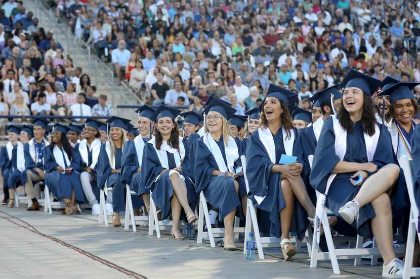 Graduates laughed at images on a big screen during the Allen High School graduation at Eagle...