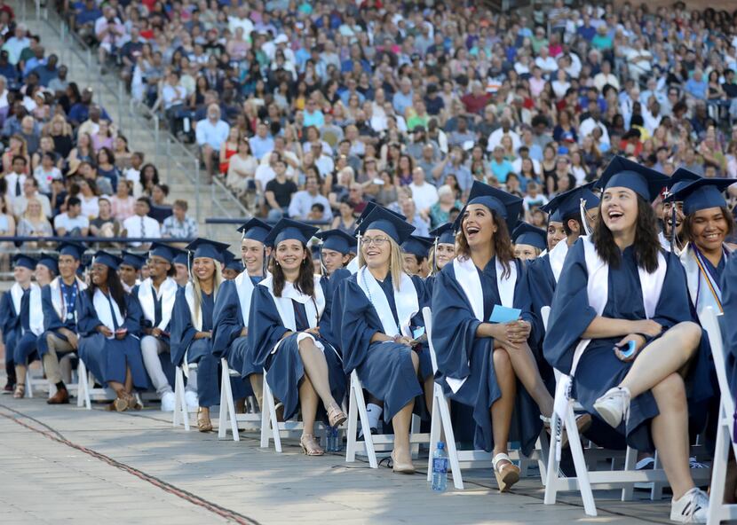 Graduates laugh at images on a big screen during the Allen High School graduation at Eagle...