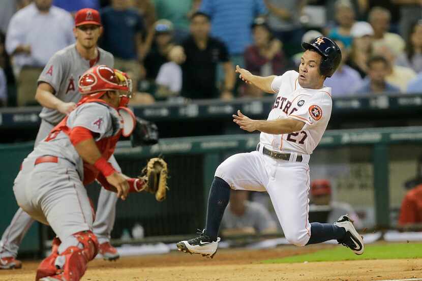 HOUSTON, TX - SEPTEMBER 21:  Jose Altuve #27 of the Houston Astros is out at home trying to...