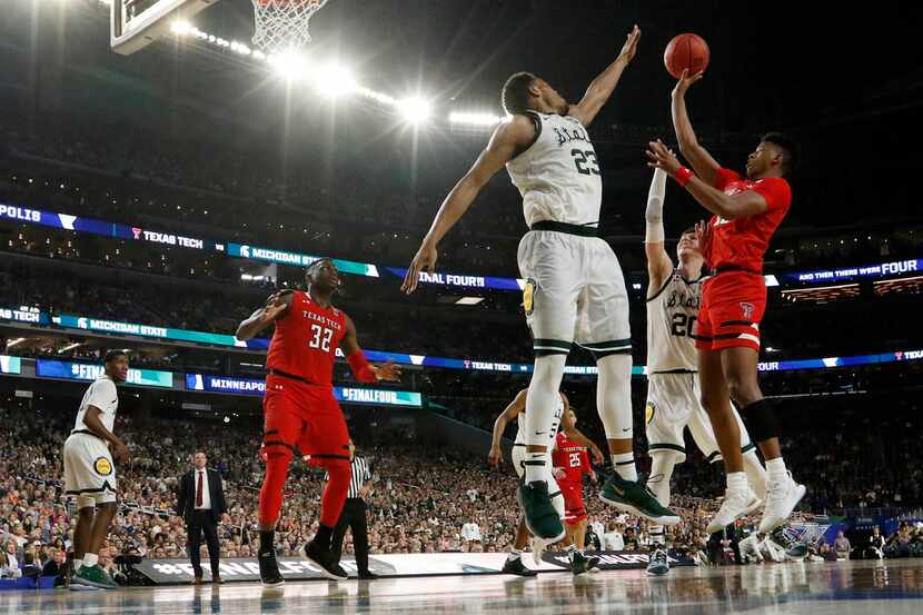 Texas Tech Red Raiders guard Jarrett Culver (23) takes a shot as he is defended by Michigan...