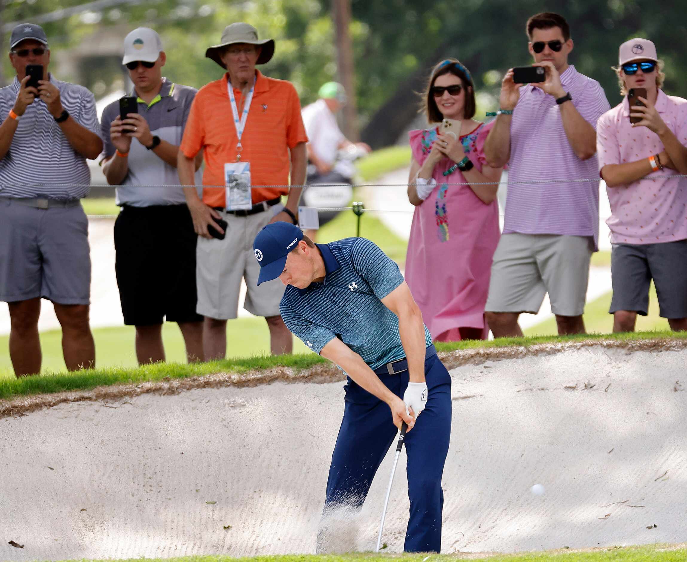 Professional golfer Jordan Spieth fires his shot out of the fairway bunker on No. 17 during...