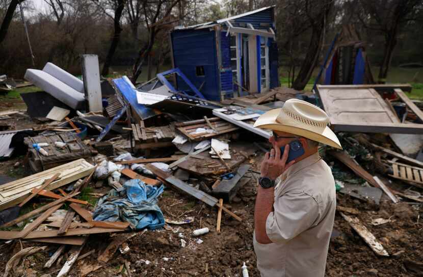 Greenspace Dallas CEO Rick Buckley makes a call as he assesses a flooded-out encampment home...
