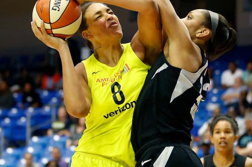 Dallas Wings center Liz Cambage (8) powers past the defensive pressure of Las Vegas Aces...