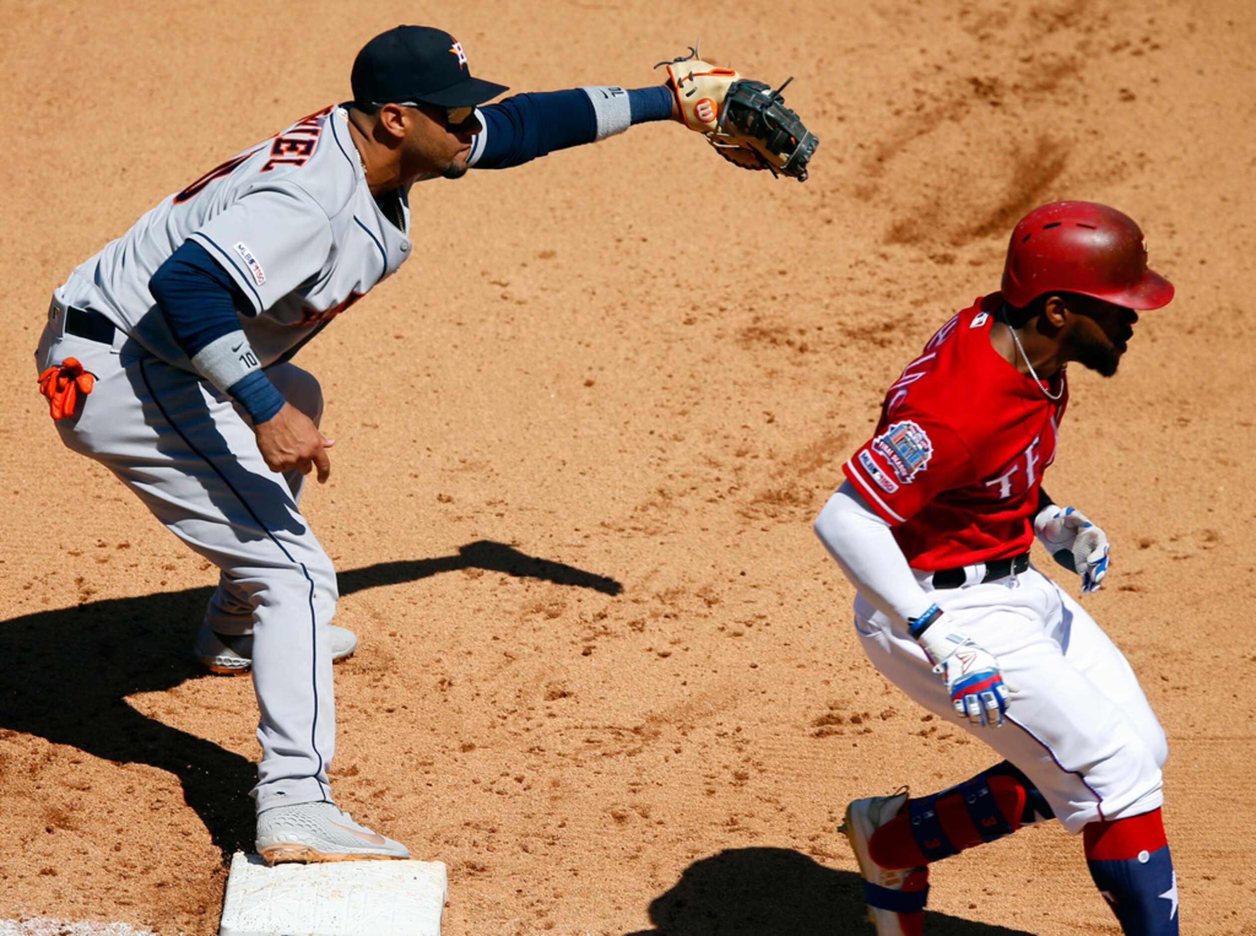 Texas Rangers left fielder Delino DeShields is safe at first after beating the throw to...