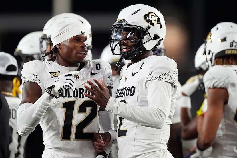 Colorado wide receiver Travis Hunter, left, confers with quarterback Shedeur Sanders in the...