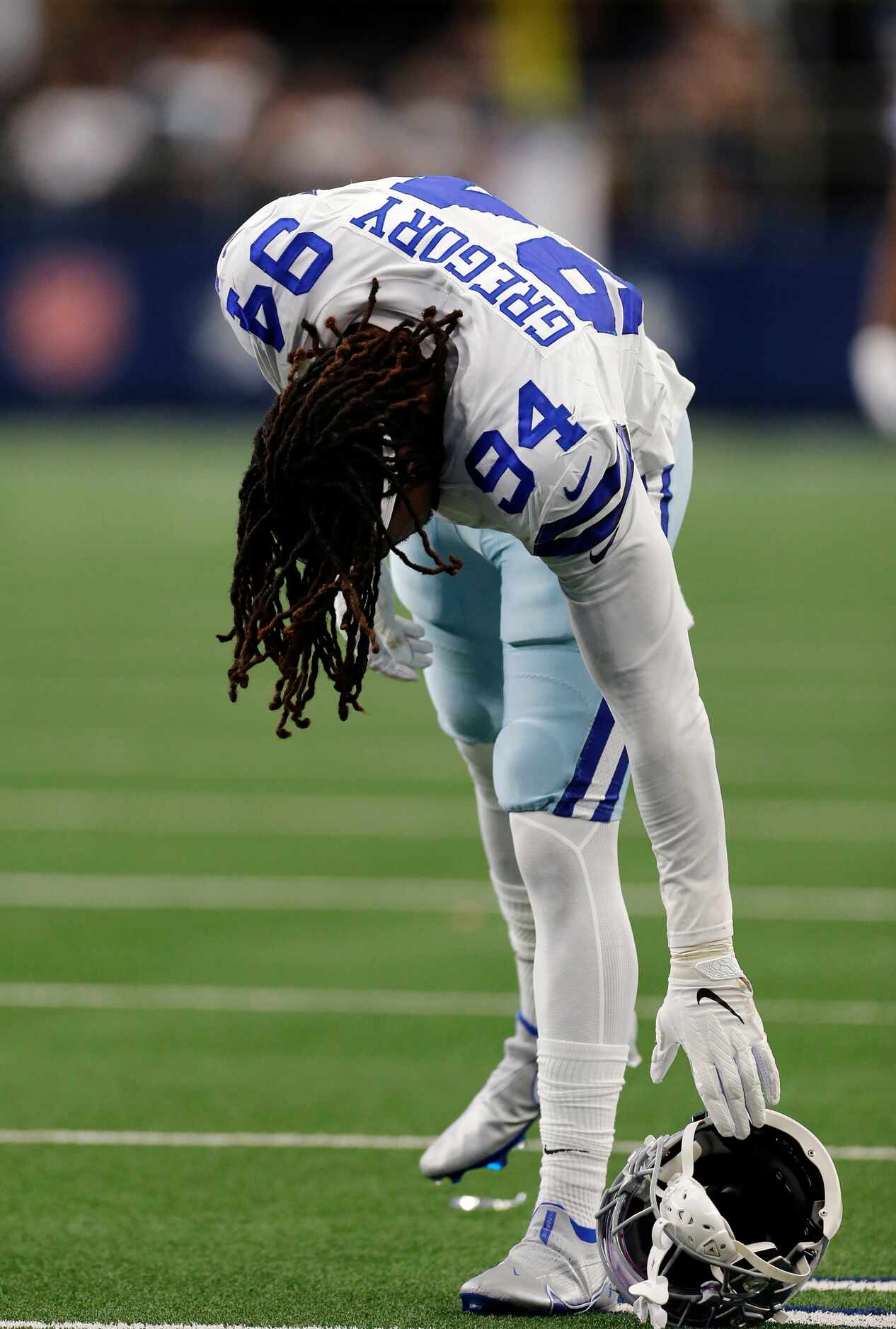 Dallas Cowboys defensive end Randy Gregory (94) retrieves his helmet after it was ripped off...