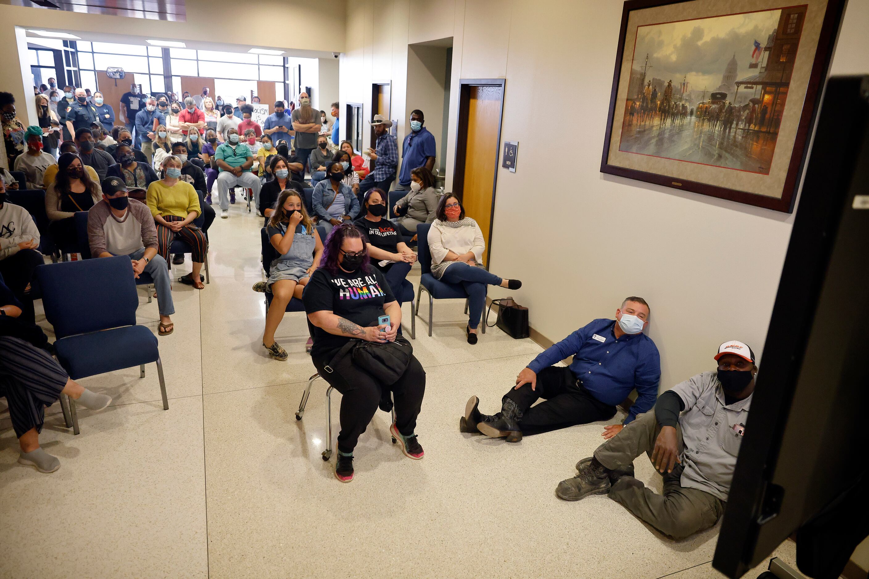 From the hallway, an overflow crowd of parents and supporters watched a closed-circuit video...