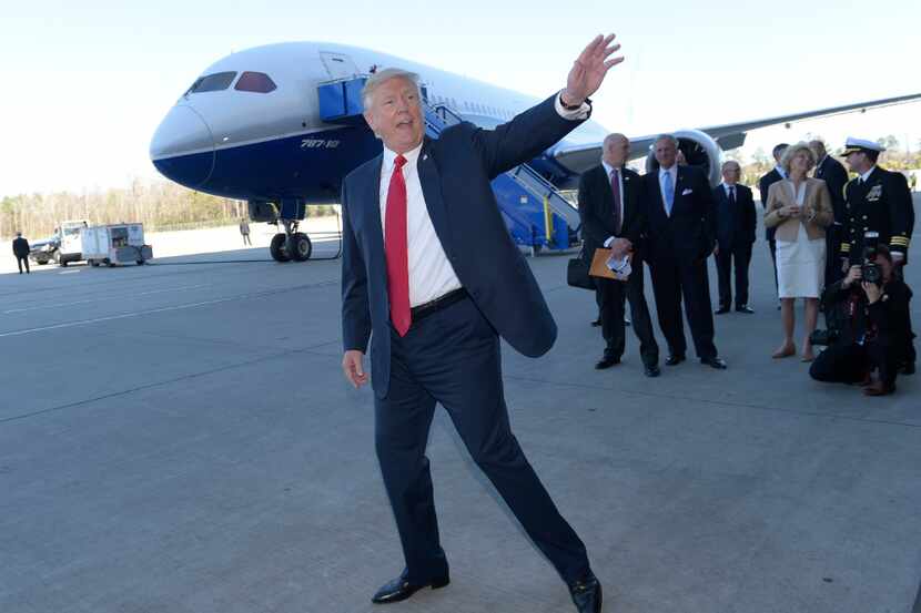 President Donald Trump waves in front of the Boeing 787 Dreamliner while visiting the Boeing...