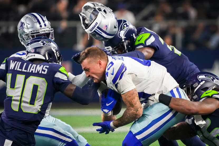 Dallas Cowboys tight end Peyton Hendershot (49) has his helmet knocked off on a hit by...