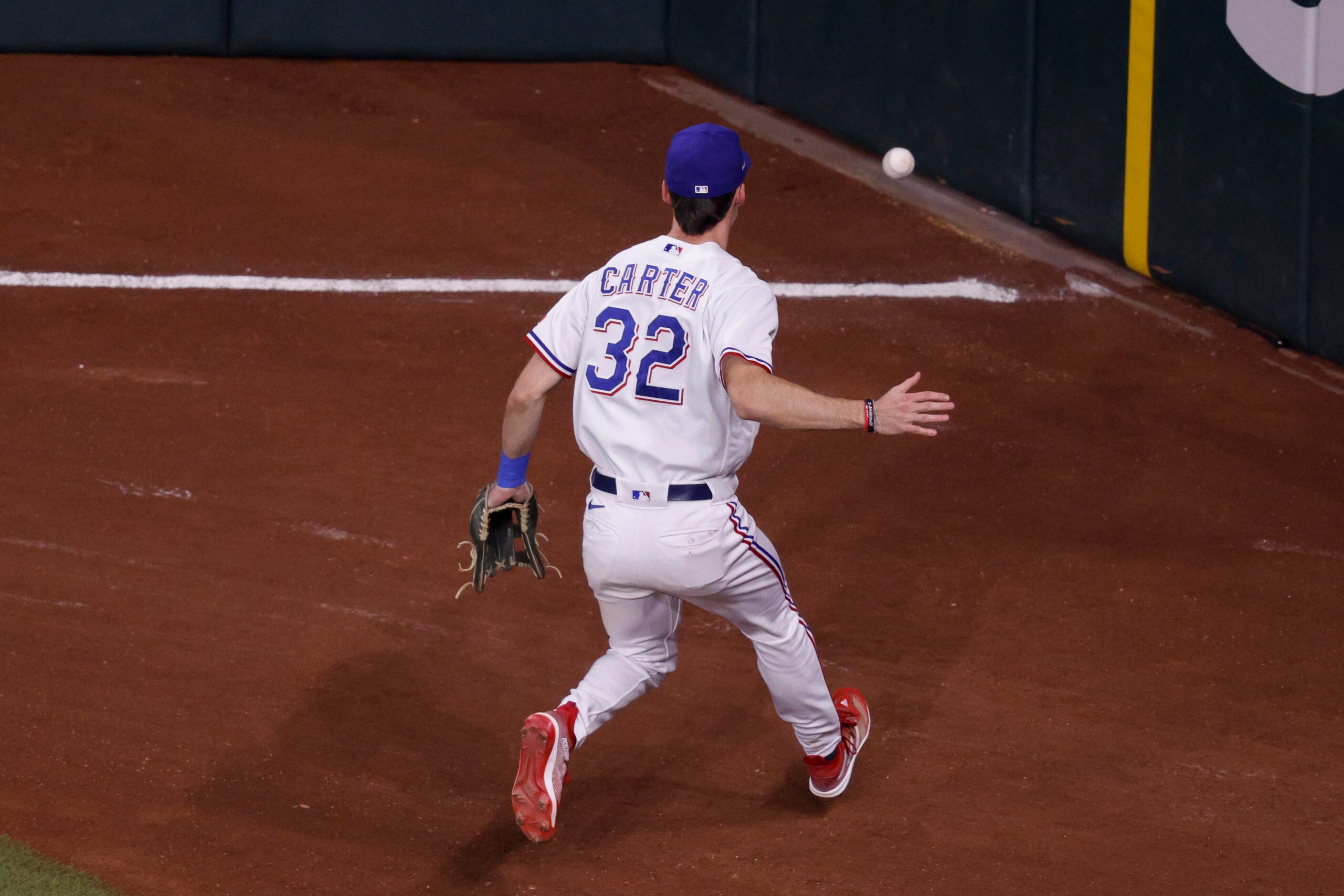 Texas Rangers left fielder Evan Carter (32) chases down a hit by Houston Astros right...