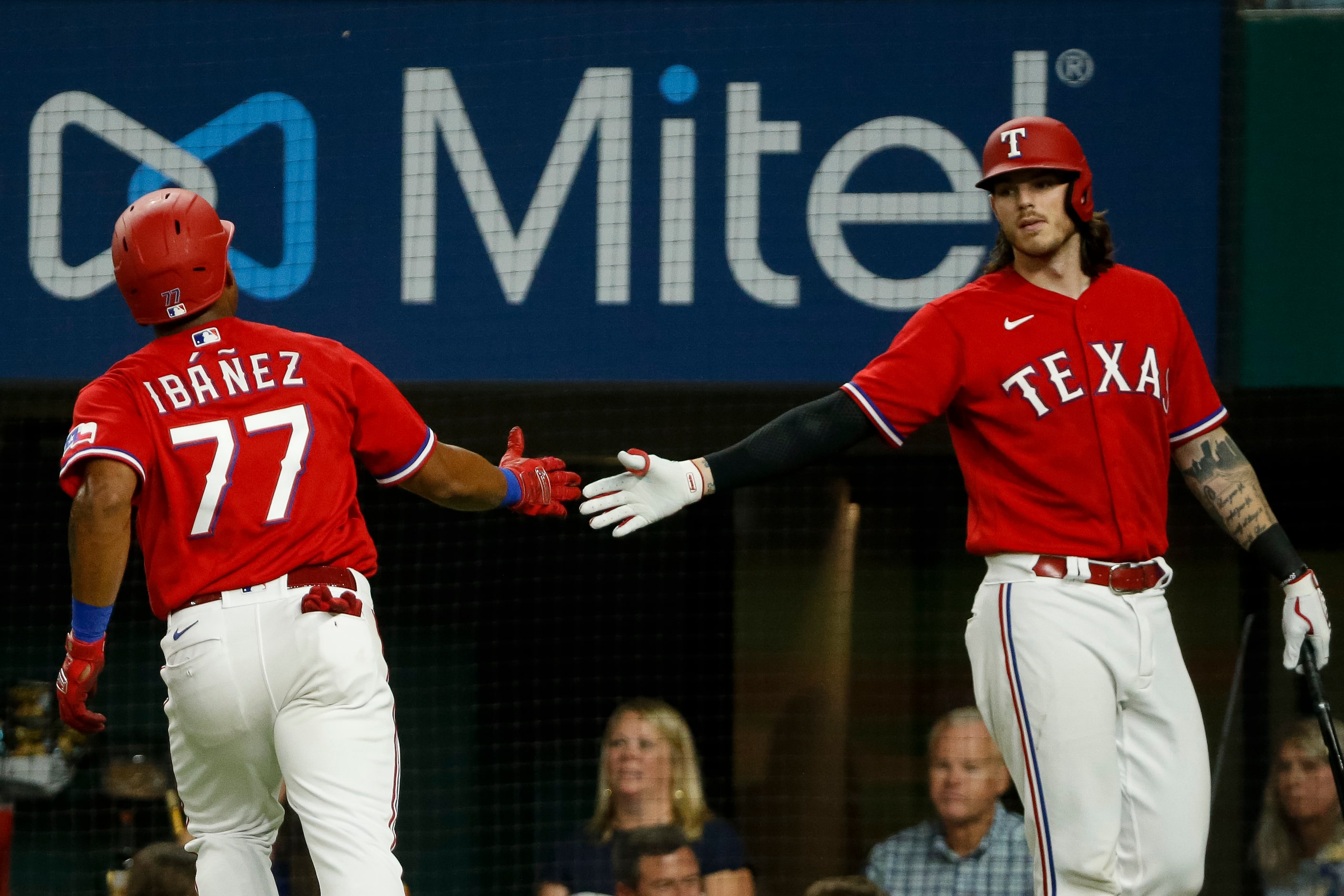 Texas Rangers designated hitter Andy Ibanez (77) high-fives Texas Rangers catcher Jonah Heim...