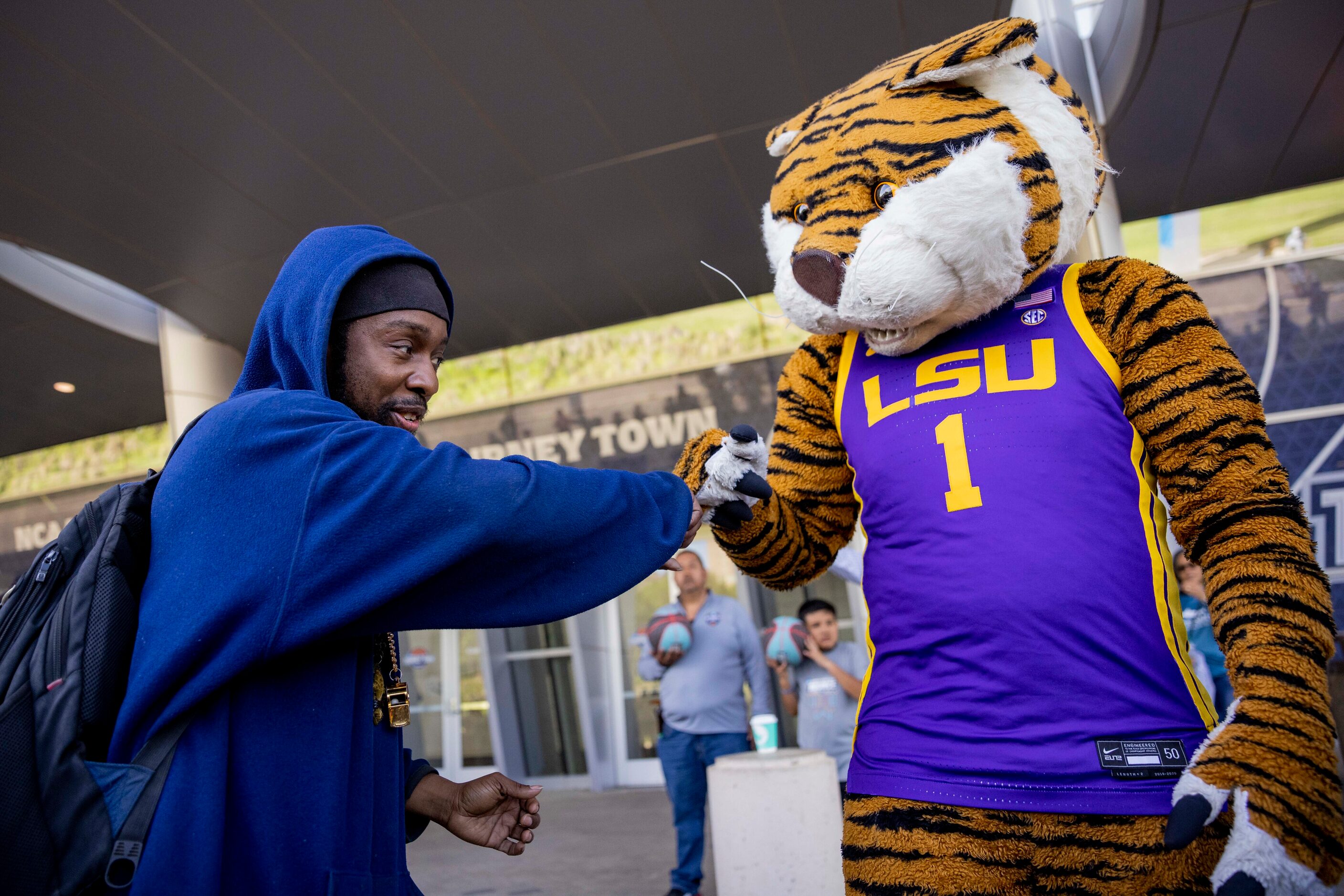 Lorenzo Taylor of New Orleans fist bumps LSU’s mascot “Mike the Tiger” at the Kay Bailey...