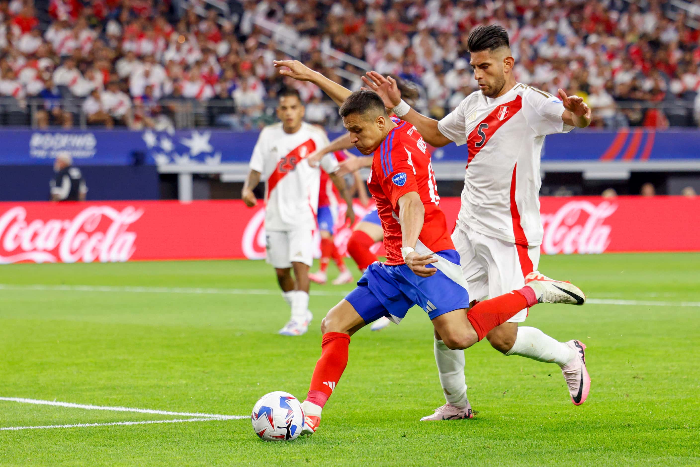 Chile forward Alexis Sánchez (10) shoots the ball ahead of Peru defender Carlos Zambrano (5)...