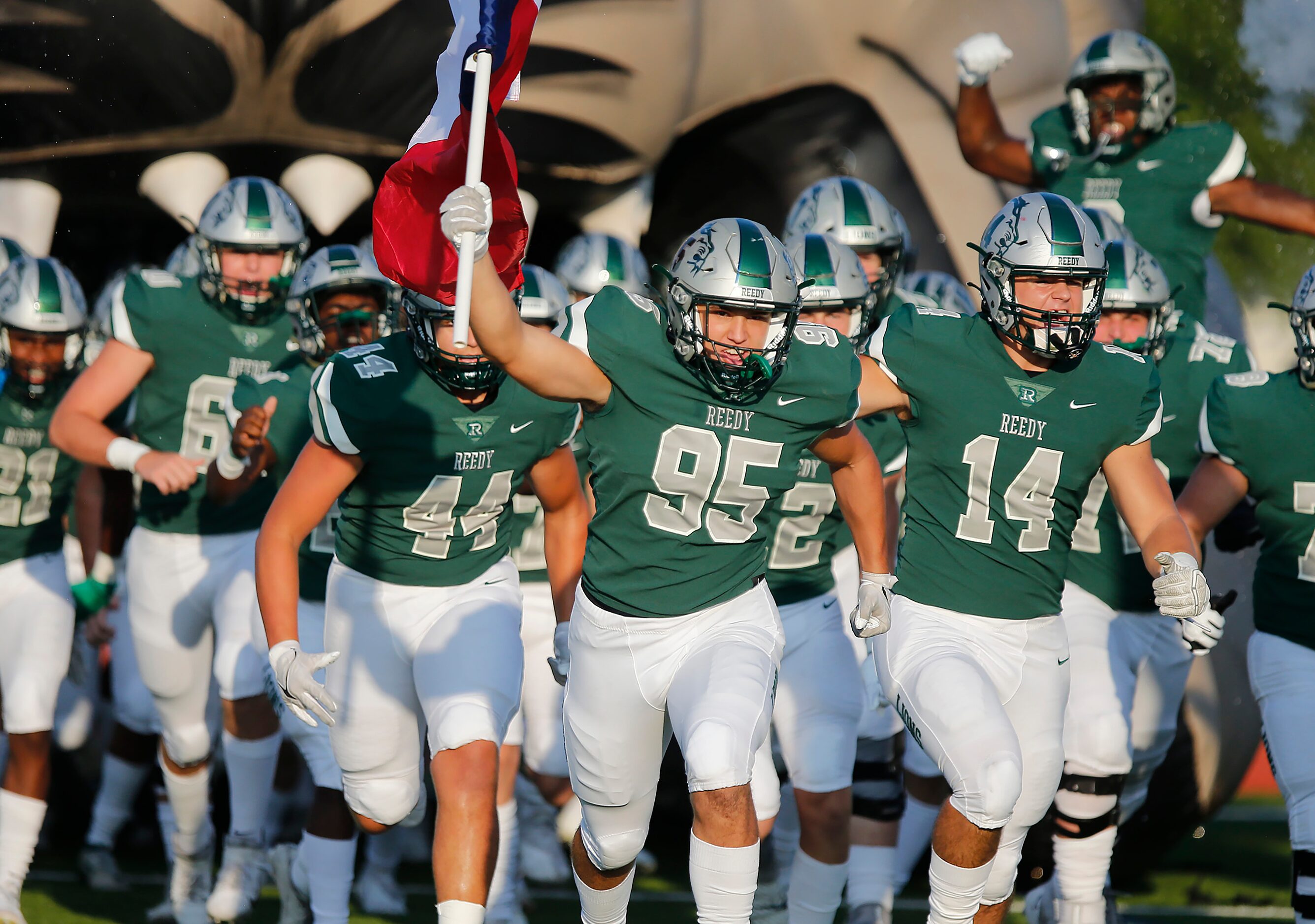 Reedy defensive tackle Chase Miller (95) leads his team onto the field holding the Texas...