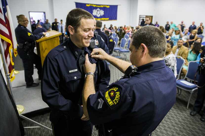 New Dallas police Officer Zachary Jones has his badge pinned on by his father, Dallas police...