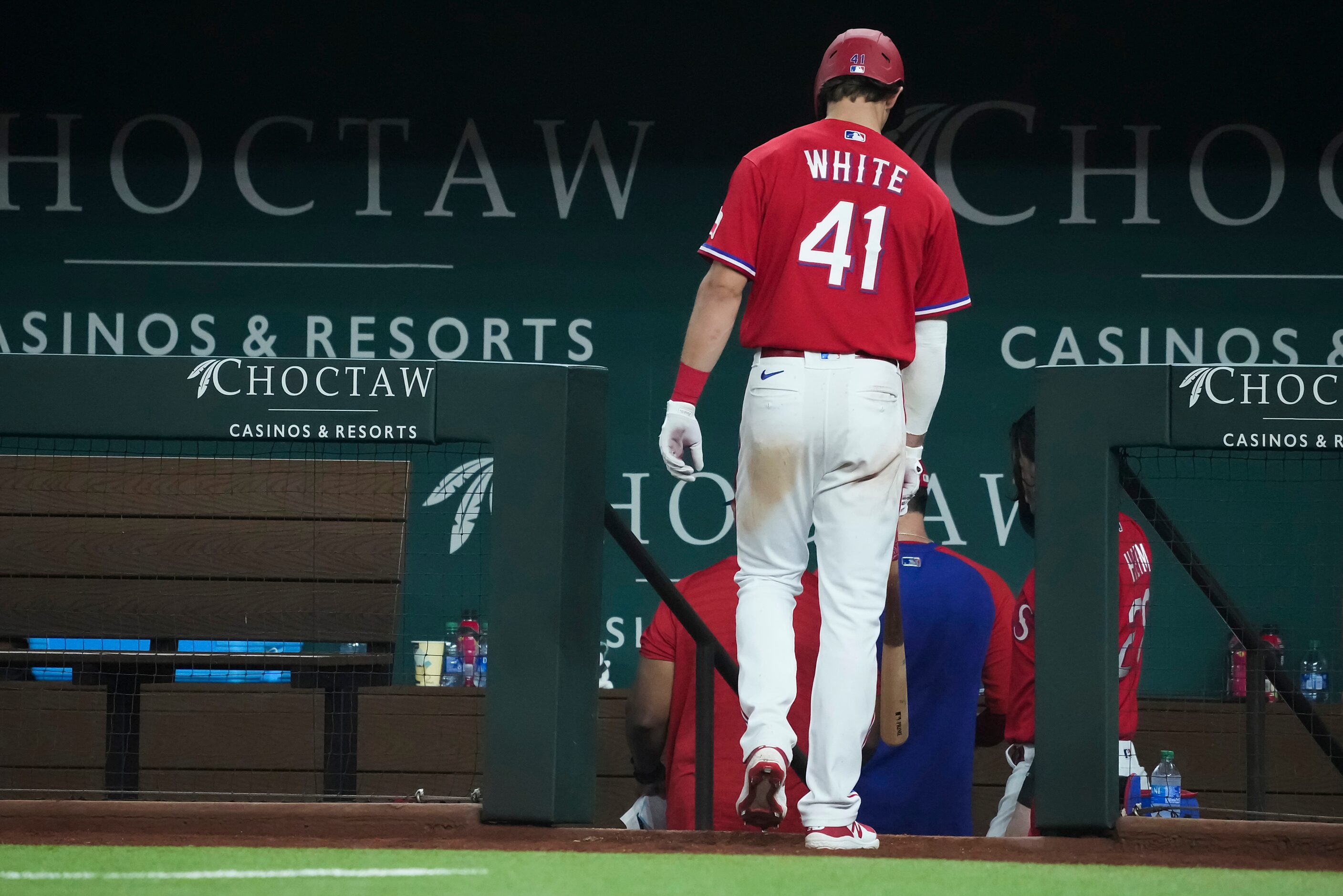 Texas Rangers left fielder Eli White heads for the dugout after striking out to end the...