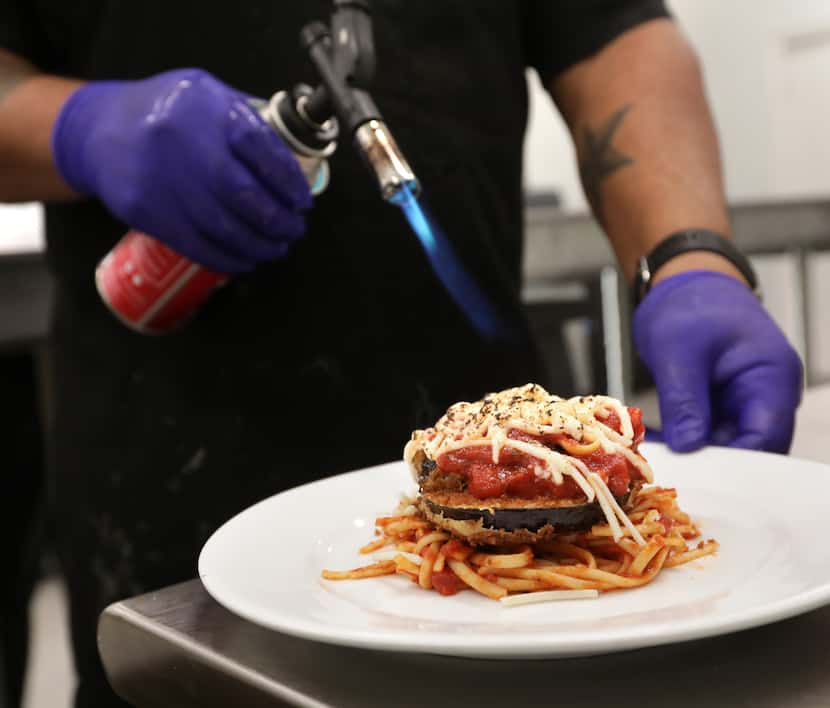 Kevin Johnson prepares a vegan dish for a wedding reception at Knotting Hill Place in Little...