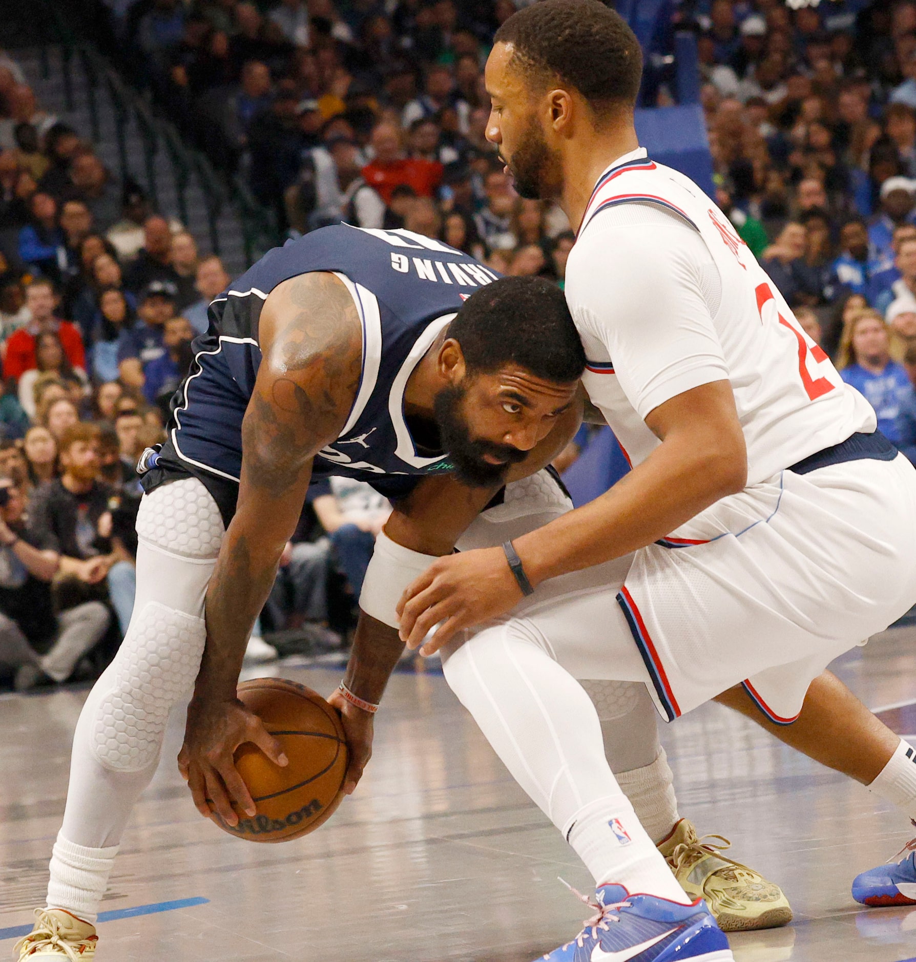 Dallas Mavericks guard Kyrie Irving (11) keeps the ball away from LA Clippers guard Norman...