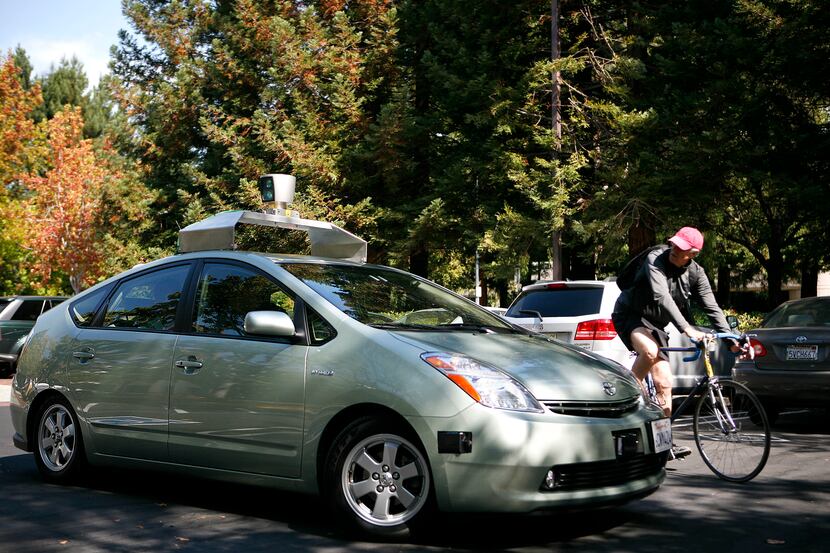 A self-driving car developed and outfitted by Google, with device on roof, at Google...